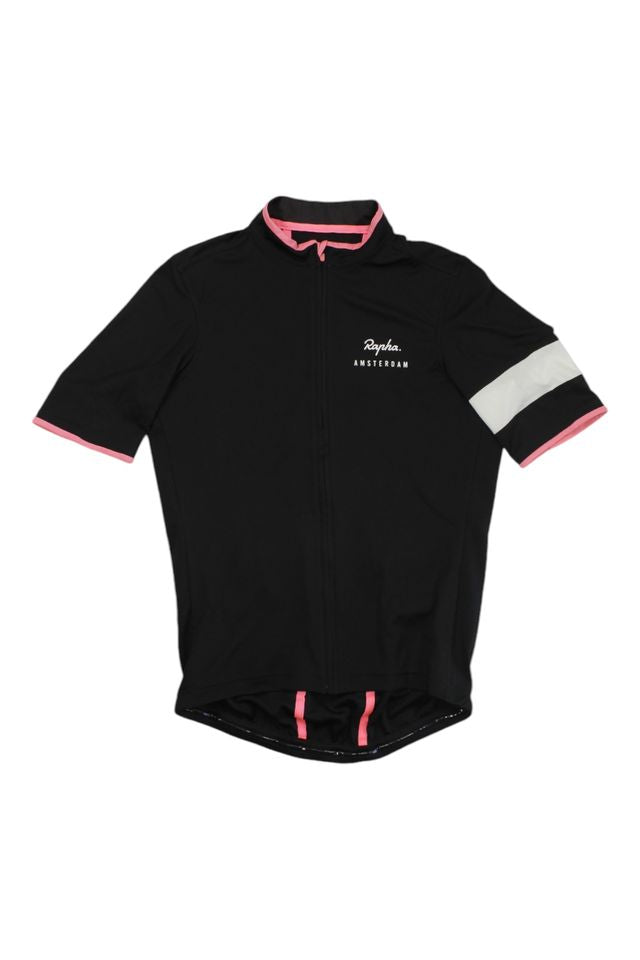 The Rapha Men's Super Lightweight Jersey features short sleeves, a black design with pink trim, a white left sleeve stripe, "Rapha Amsterdam" chest text, a full front zipper, and a slightly longer back.