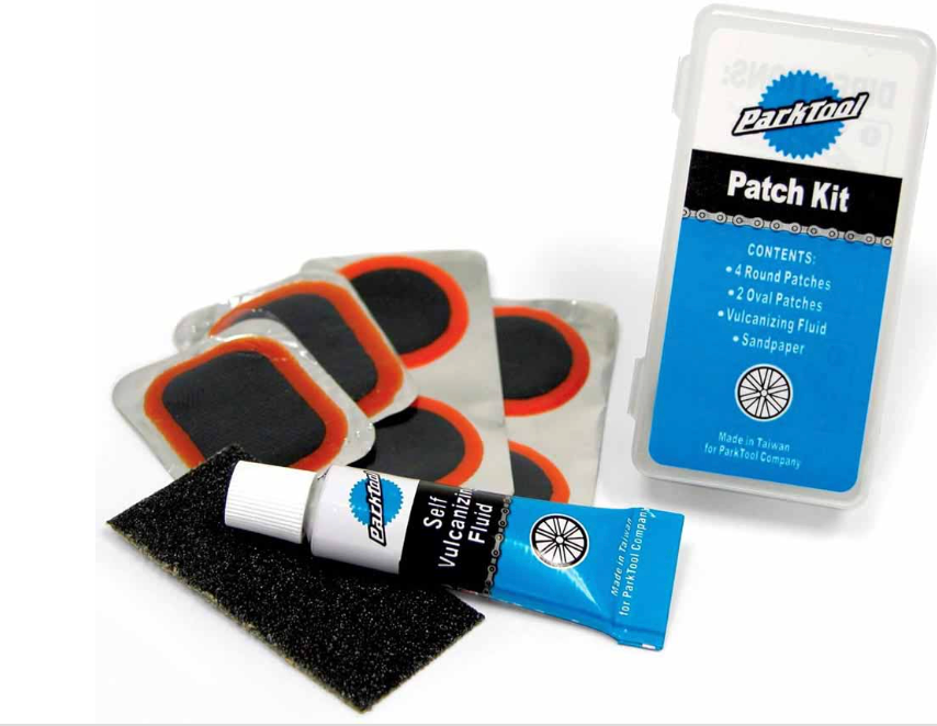 Vulcanizing patch kit with black circular patches, sanding strip, and sealed case