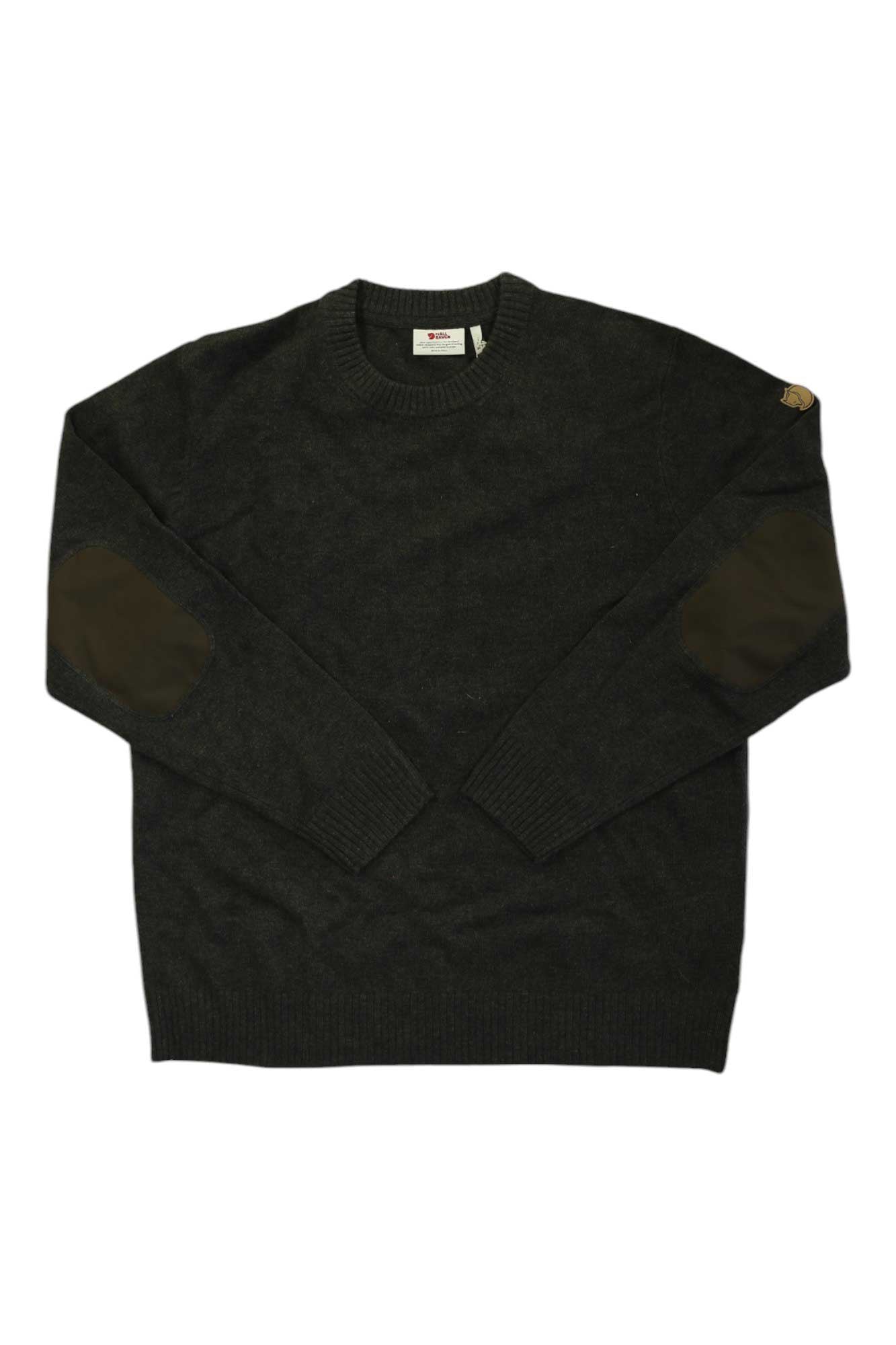 The Fjallraven Mens Ovik Round Neck Sweater is a dark gray crewneck with ribbed cuffs and hem, brown G-1000 reinforced elbow patches, and a small logo patch on the left sleeve. Shown laid flat on a white background.