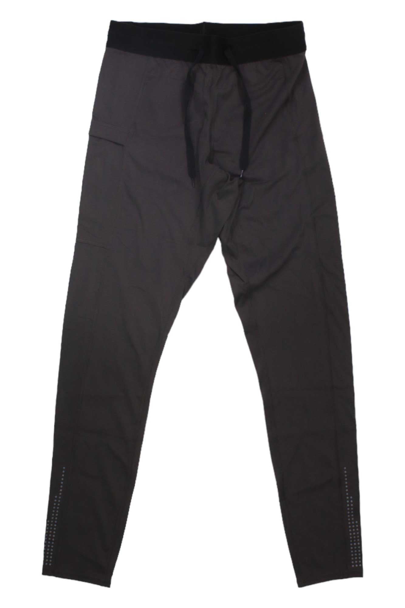 The Eddie Bauer Mens Resonance Training Tight features dark gray fabric, a black elastic waistband, black drawstring, slim-fit legs, moisture-wicking material, and small reflective details near the bottom of each leg.