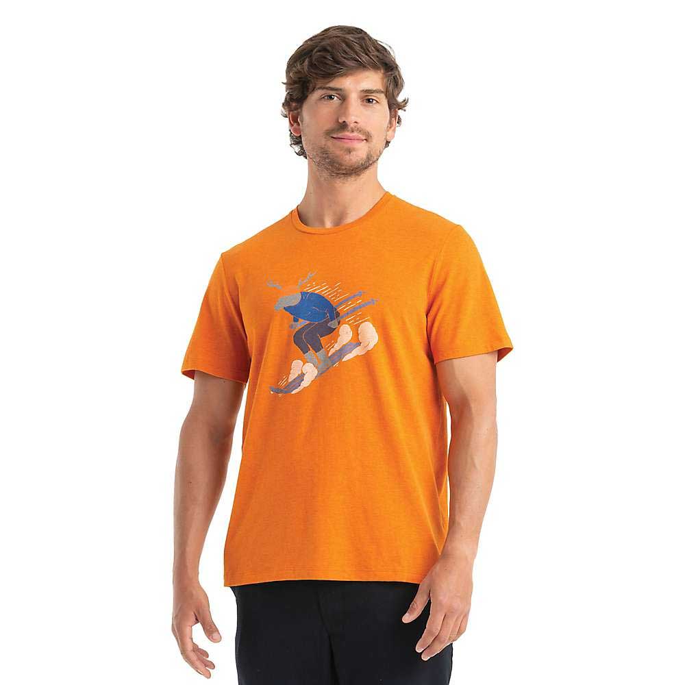 A man wearing the Icebreaker Mens Merino Central Classic Ski Rider SS Tee, an orange graphic t-shirt featuring a snowboarder, stands facing forward against a white background—perfect for hiking or casual outings.