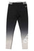 The Picture Women's Caty Tech Legging features a gradient from black at the waist to light gray at the ankles, a white geometric logo and text on the lower left leg, a black-and-white striped waistband, and moisture-wicking fabric.