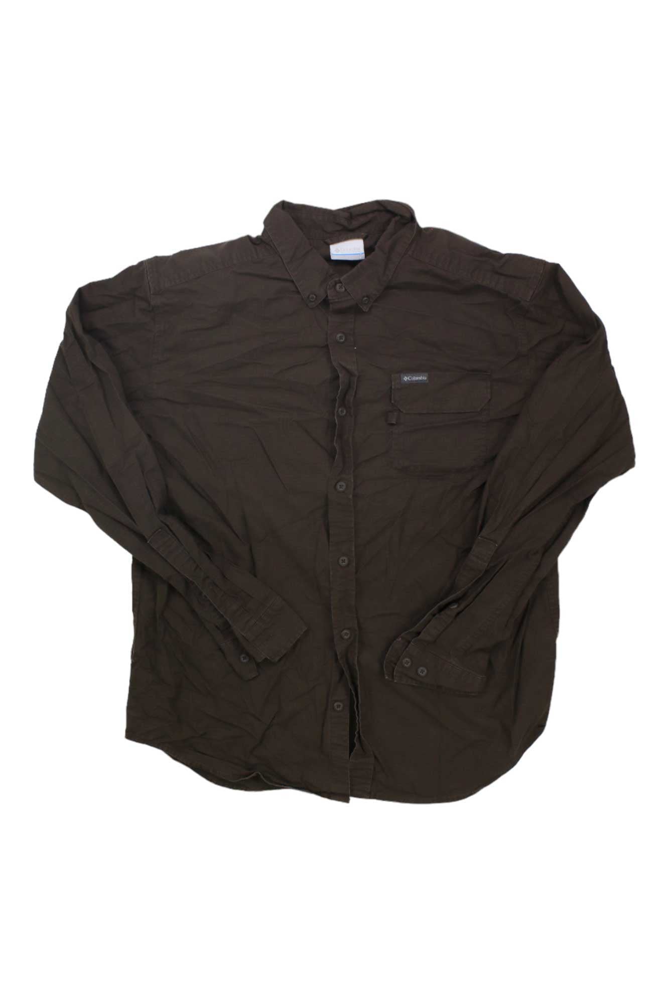 The Columbia Men's Rapid Rivers Ripstop Woven Long Sleeve is a dark brown, comfort stretch cotton button-up with a collar and single chest pocket, shown laid flat on a white background.
