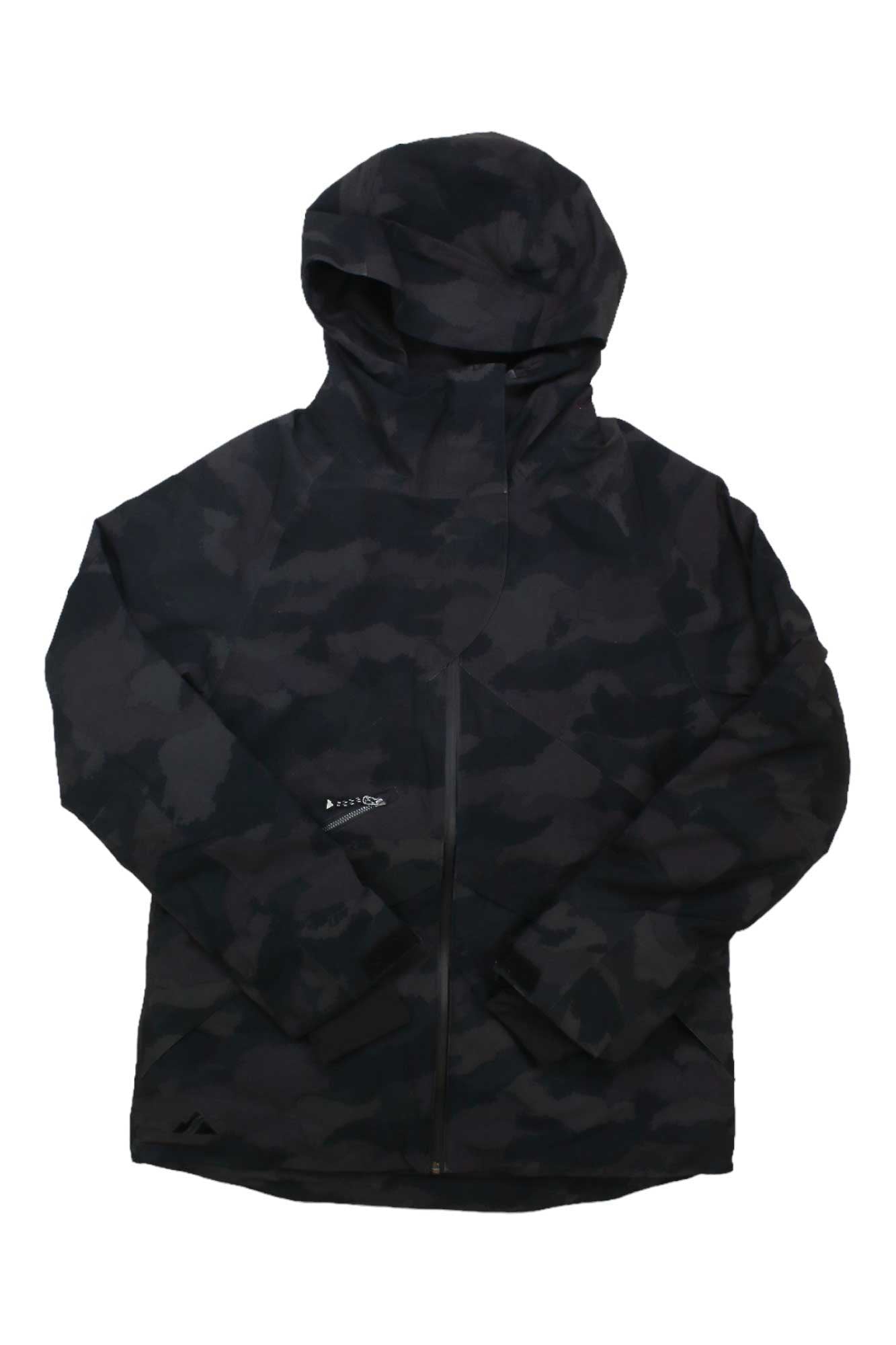 The Strafe Womens Lucky Jacket is a black and dark grey camo waterproof ski jacket with a front zipper, long sleeves, and subtle logo details on the chest and lower front, shown laid flat on a white background.