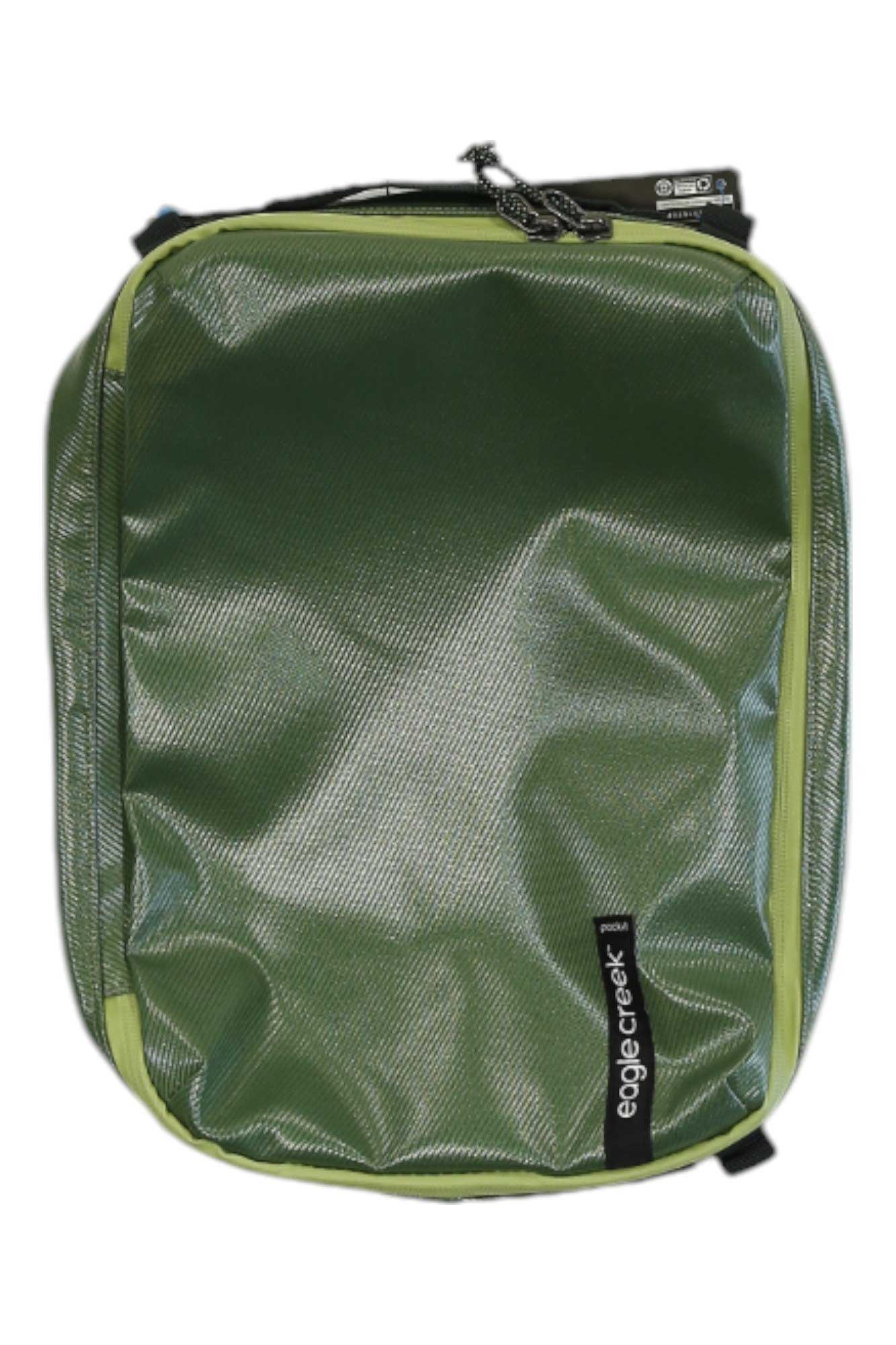 A green Eagle Creek Pack-It Gear Cube M, made from durable, water-resistant fabric with a zipper closure, features the brand label on the front. The rectangular packing cube lies flat on a white background.