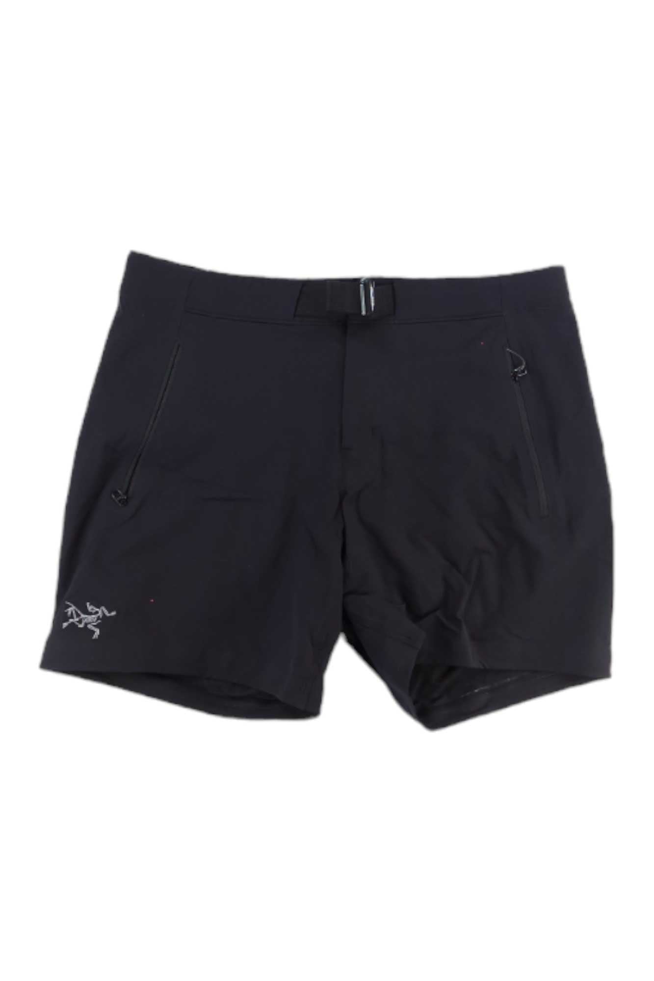 The Arcteryx Womens Gamma LT 6 Inch Short features black fabric, zippered side pockets, a small white logo on the left leg, and an integrated waistband belt. Shop this exclusive style for US addresses only. Shown laid flat on a white background.