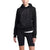A person wears The North Face Womens Trivert Pullover Hoodie made from recycled materials with a large logo, paired with black bike shorts, standing against a white background.