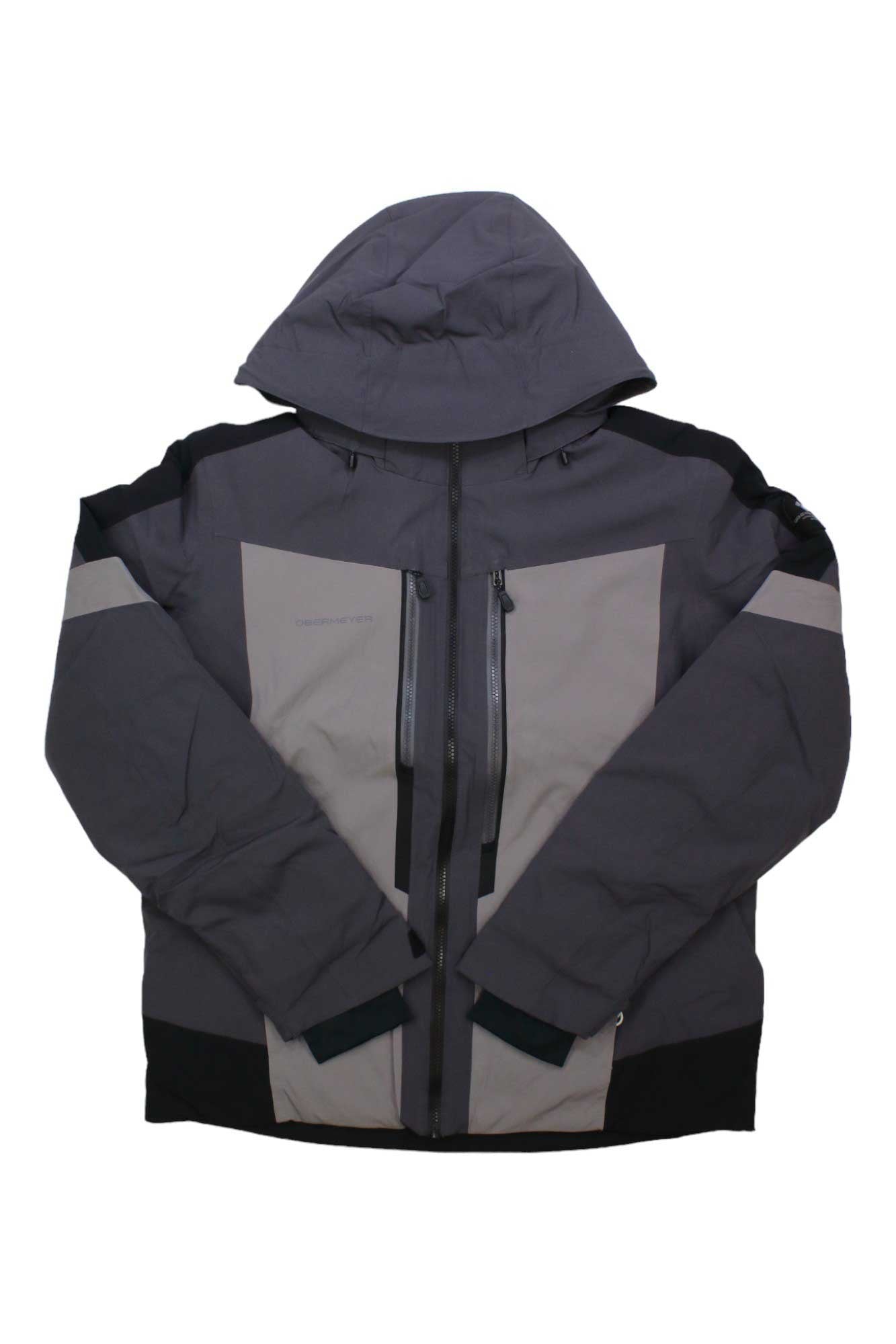 The Obermeyer Men's Fall Line Jacket features a gray and black color-blocked design, front zipper closure, two vertical zippered chest pockets, and is waterproof—perfect for casual cold weather adventures.