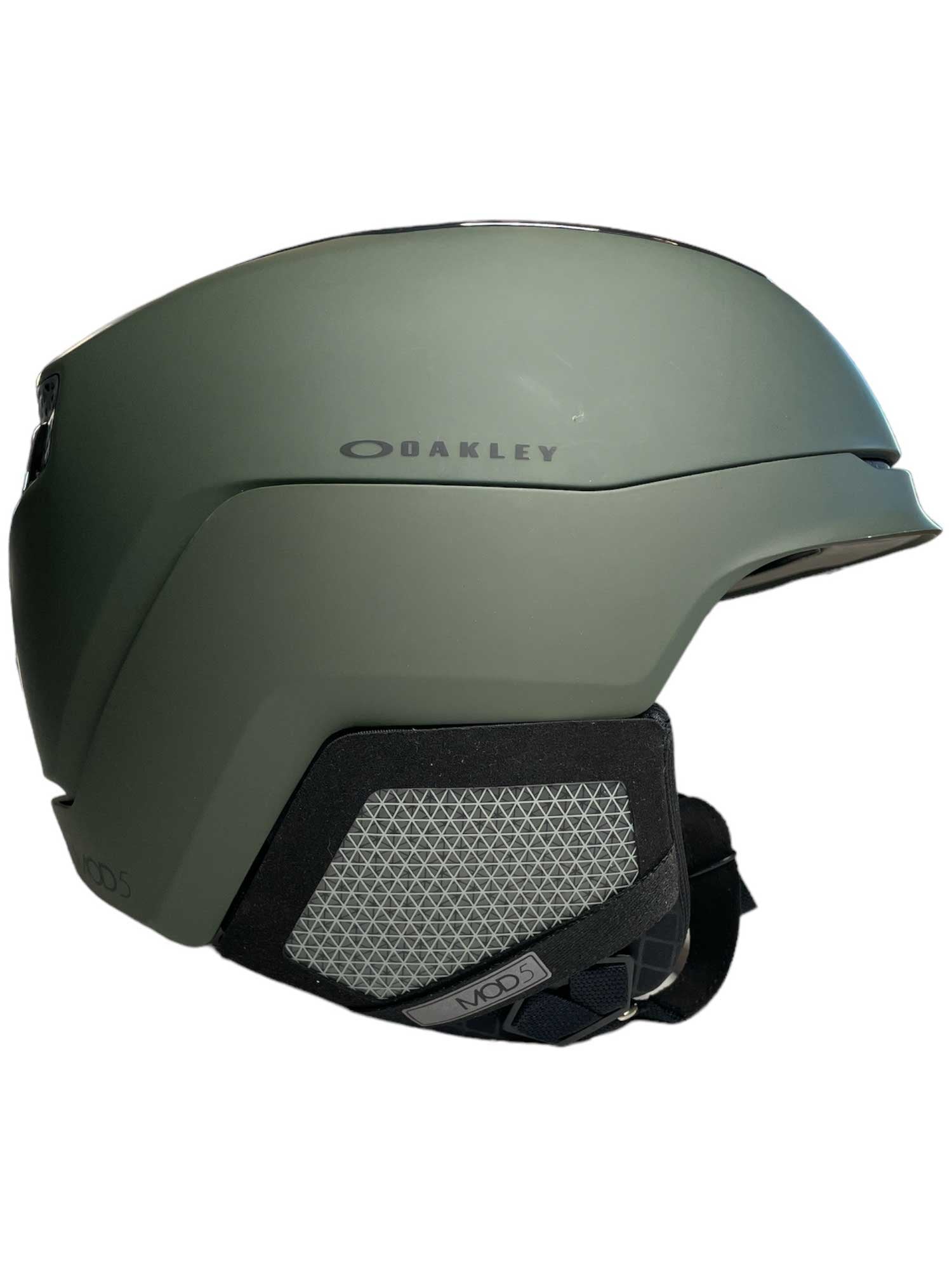 The Oakley Mod 5 Helmet features a matte green finish, sleek design, adjustable ventilation, black padded ear covers and chin strap, visible side Oakley logo, plus seamless goggle integration for ultimate performance.