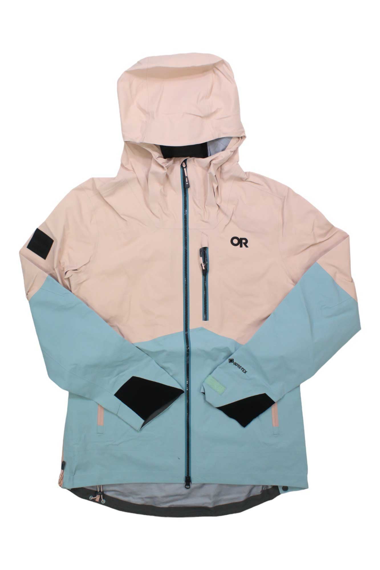 The Outdoor Research Womens Hemispheres II Jacket is a two-tone waterproof jacket with a hood, light beige on top and light blue below. It features a front zipper, a zippered chest pocket, and the OR logo—ideal for any outdoor adventure.