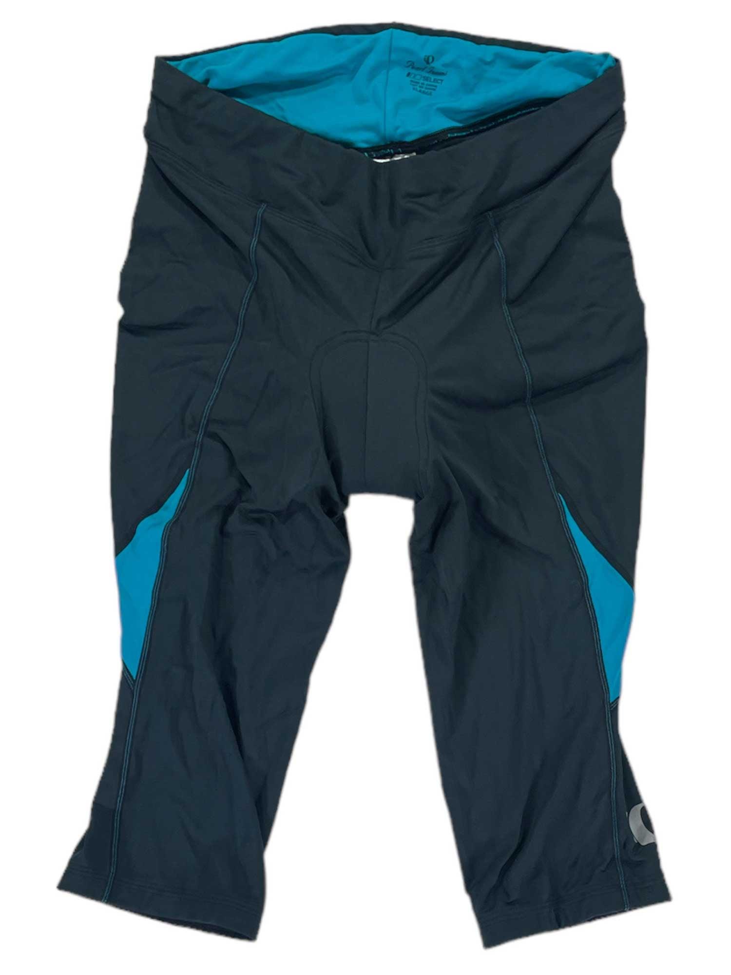 Laid flat on a white background, the Womens Sugar Knicker features black and blue padded cycling shorts with three-quarter length legs, Sensor fabric, a women’s-specific chamois, blue inner lining, and side panels.