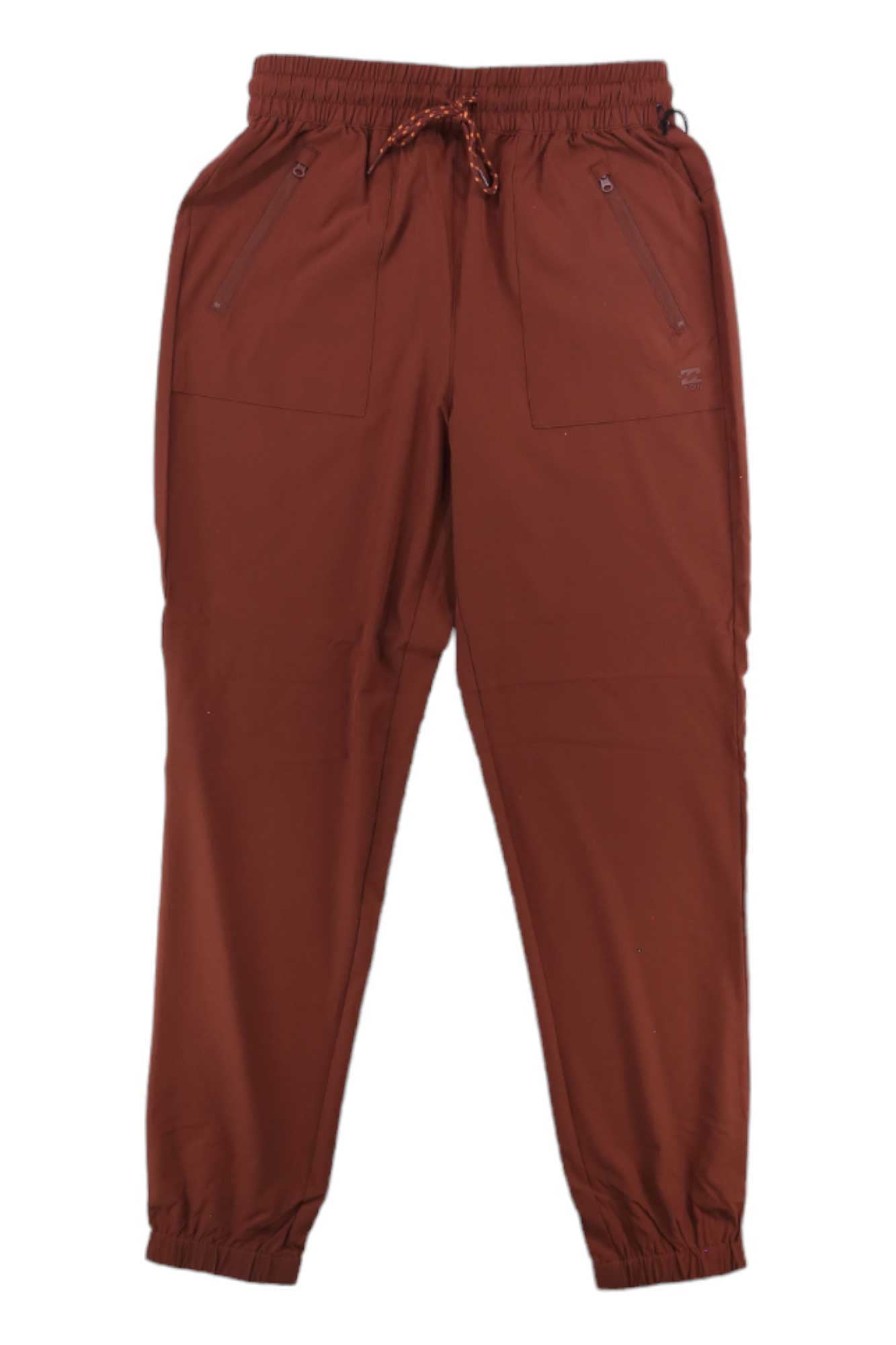 The Billabong Womens Canyon Jogger features a rust color, elastic waistband, adjustable drawstring, front zipper pockets, and elastic cuffs—moisture-wicking travel pants designed for all-day comfort.