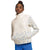 A woman with her hair in a bun wears The North Face Womens Alpine Polartec 100 1/4 Zip Cowl Top in cream and light blue, standing with hands in the front pocket and pairing the cozy pullover with bright blue leggings.