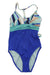 The Carve Designs Womens Dahlia One Piece features a blue bottom, turquoise waistband, geometric patterned top in blue, turquoise, beige, and white, adjustable straps for a secure fit, and sun-protective fabric for comfort.