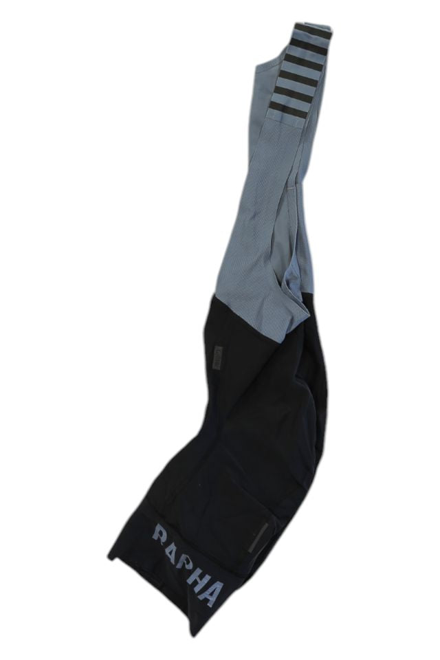 A pair of Rapha Mens Pro Team Bib Shorts II - Regular in black and gray with RAPHA on the lower leg, striped strap detail, and race-grade chamois, shown isolated on a white background.