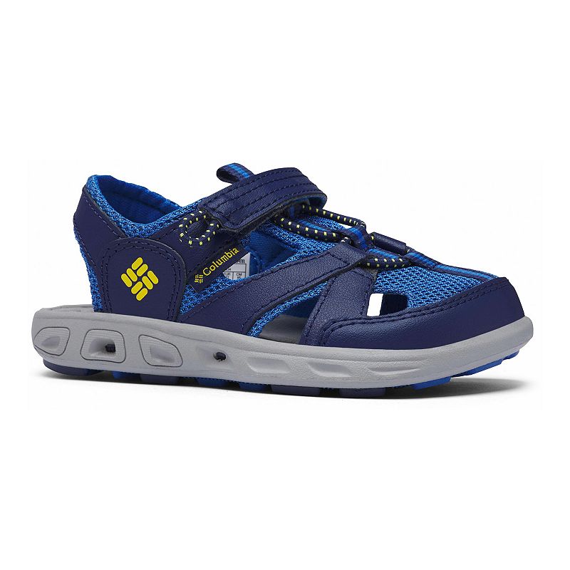 The Columbia Kids Techsun Wave Sandals feature a blue and navy mesh upper, closed toe, velcro strap, light gray sole, and yellow branding—making them athletic, breathable summer sandals for kids.