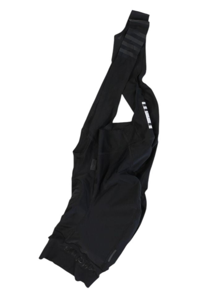A pair of Rapha Mens Pro Team Bib Shorts II - Regular with shoulder straps, race-grade chamois, and subtle reflective accents, is displayed flat on a white background.