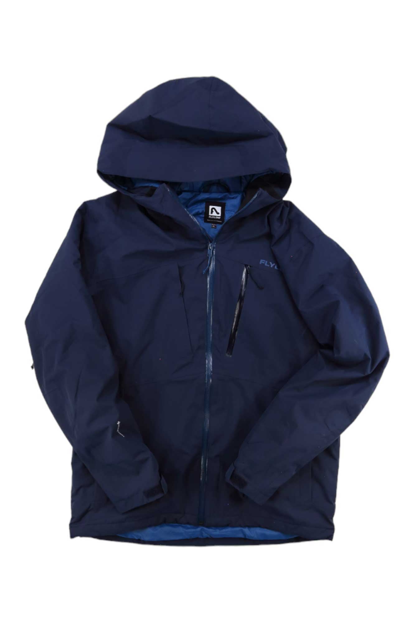 The Flylow Mens Vector Jacket is a navy blue waterproof hardshell with a front zipper, zippered chest pocket, and logo on the upper left. The men's jacket is shown laid flat on a white background.