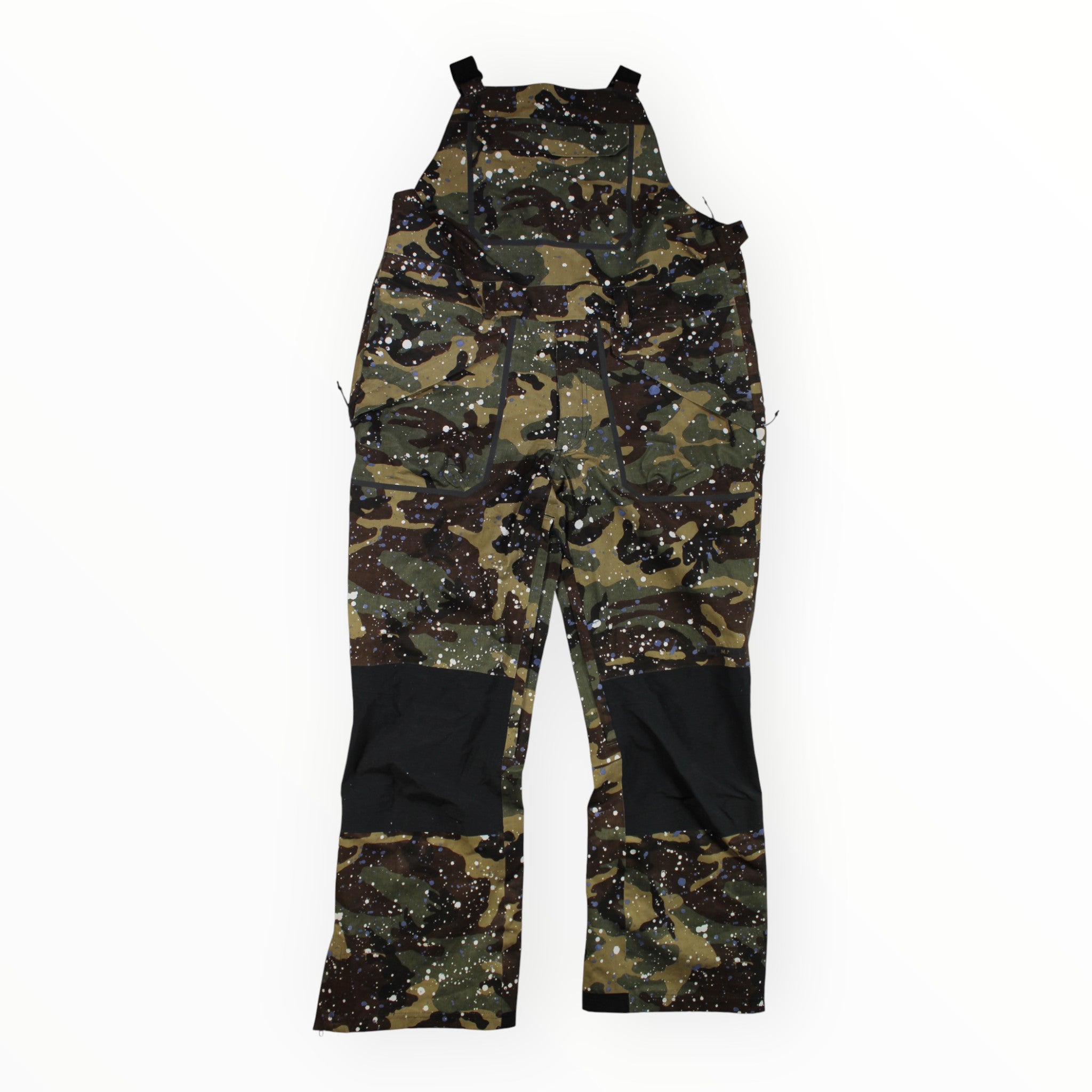 The Armada Mens Emmons 3L Bib Pant, waterproof and designed for backcountry snow sports, features a camouflage pattern with black knee patches and white paint splatter accents, shown flat on a white background.