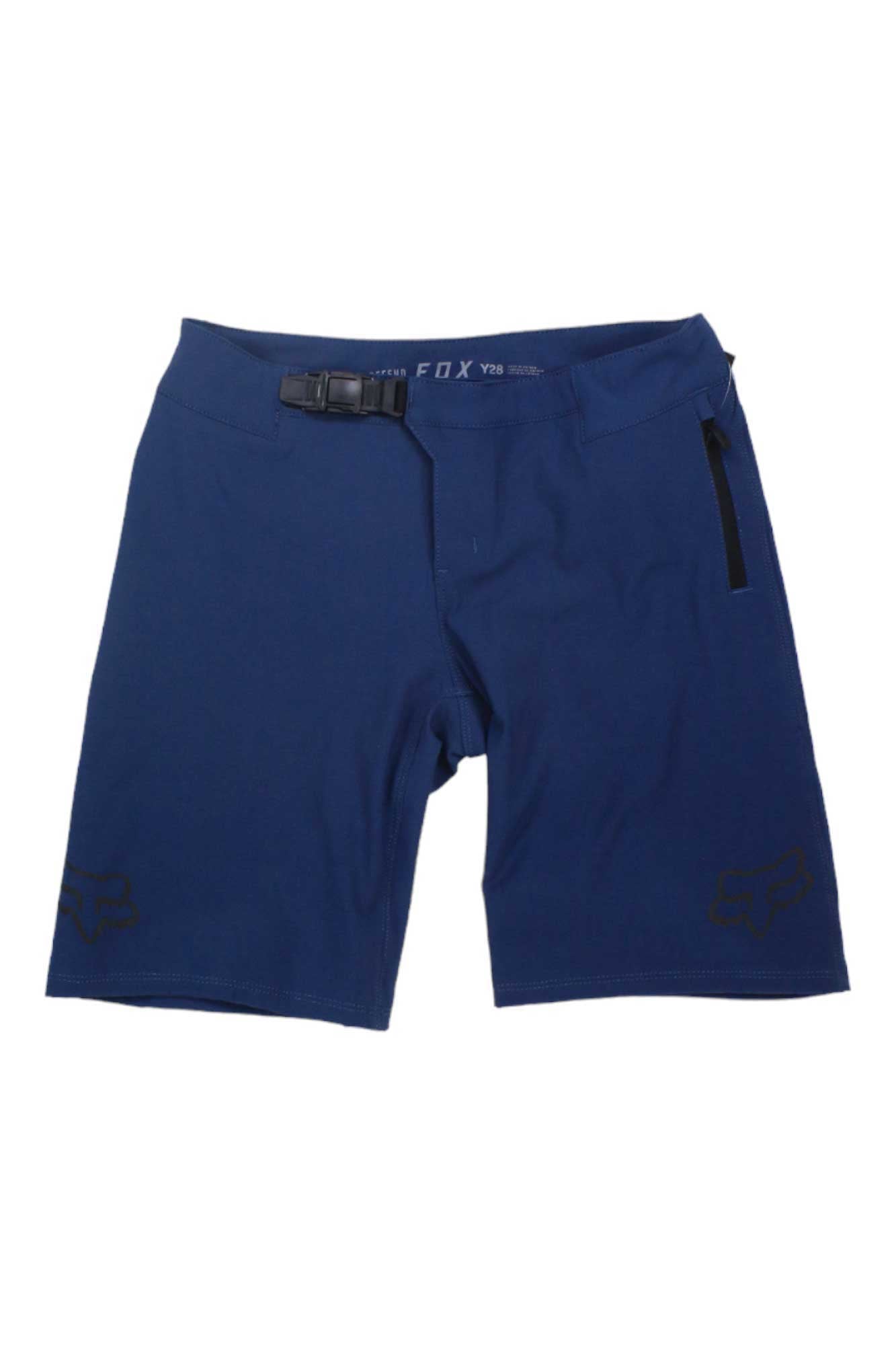 The Fox Youth Defend Short is a navy blue, water-resistant kid’s mountain biking short featuring a right-side zipper pocket, built-in waist belt, and small black fox head logos—ideal for young riders on any adventure.