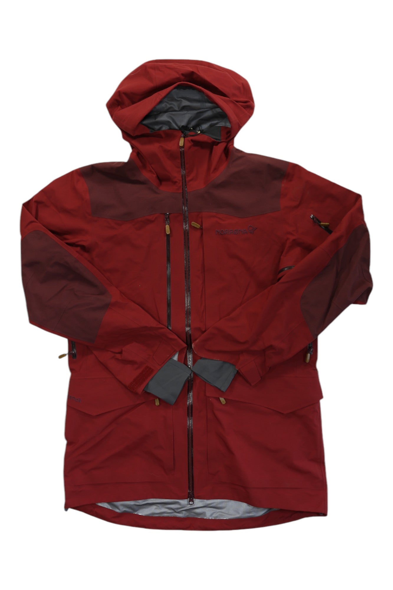 The Norrona Men’s Tamok GTX Performance Shell Jacket is a red Gore-Tex shell with brown accents, hood, zippered front, multiple pockets, and adjustable wrist cuffs—perfect as a waterproof outdoor jacket for any adventure.