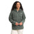 A woman with curly hair wears the Women's Ridge Fleece Tunic, a textured green pullover with a half-zip and front pocket. She stands against a plain white background, facing forward with her hands clasped.
