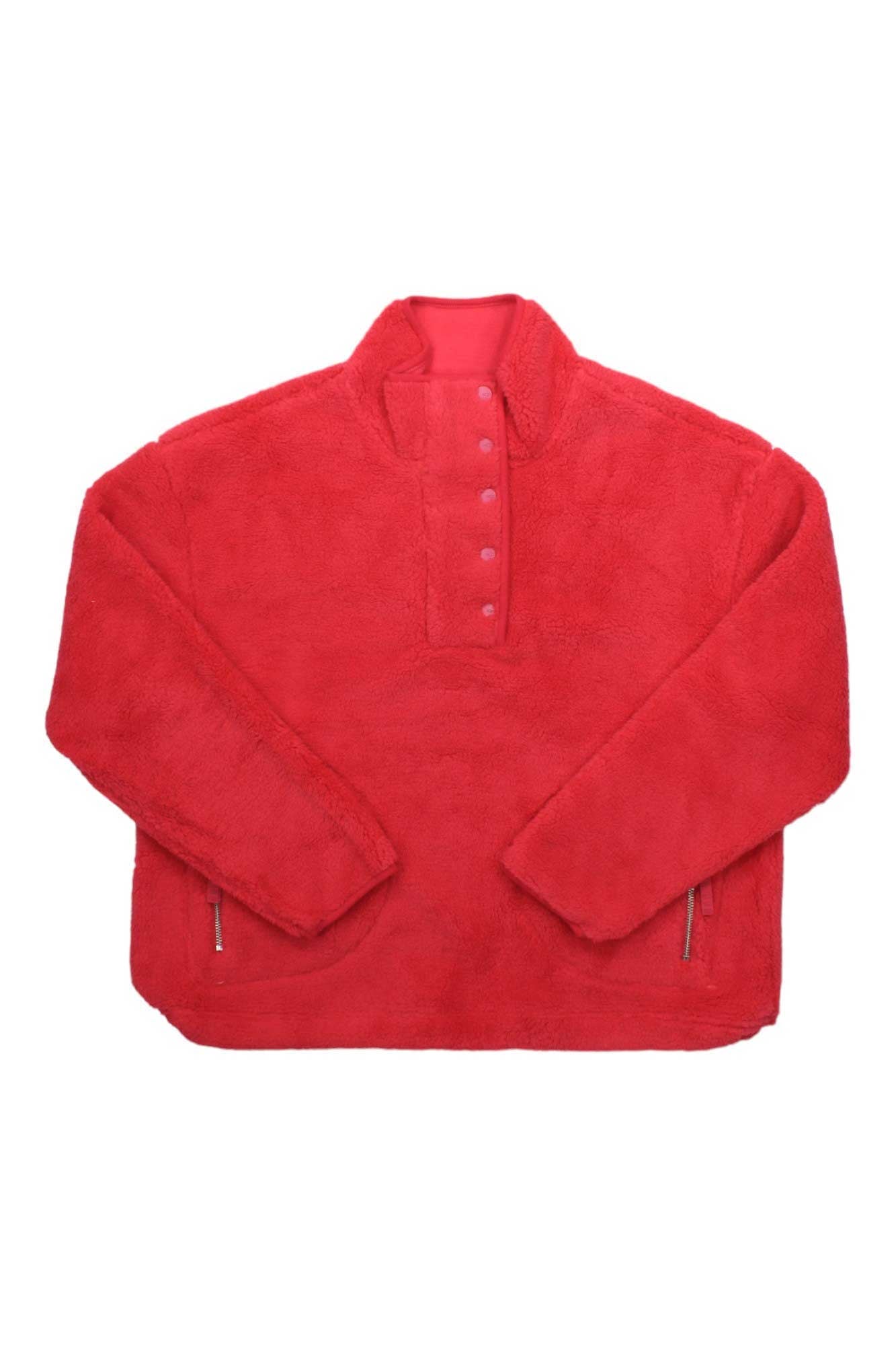 The Ugg Womens Atwell Sherpa Half Snap Pullover is a bright red fleece with a stand-up collar, snap button placket, long sleeves, and zippered side pockets. Shown laid flat on a white background, it’s ideal as a casual travel sweater.