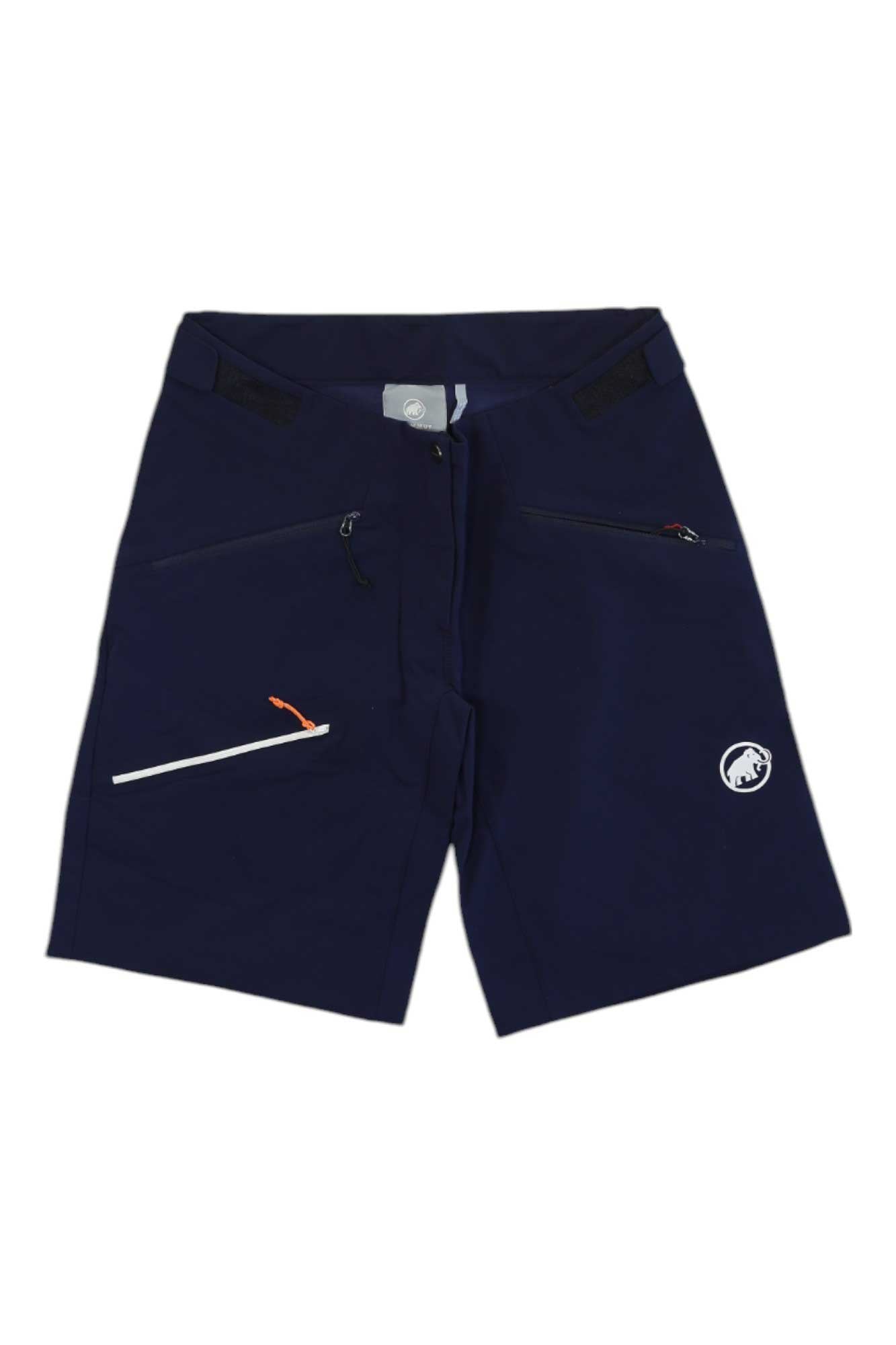 The Mammut Womens Taiss SO Short in navy blue features three zippered pockets, including a white zipper with orange pull and a white mammoth logo on the left leg—ideal for women's outdoor gear collections.
