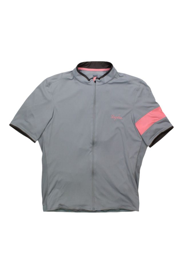 The Rapha Mens Super Lightweight Jersey is a light gray short-sleeve cycling jersey with a front zipper, subtle pink Rapha branding on the chest, and a pink armband on the left sleeve.