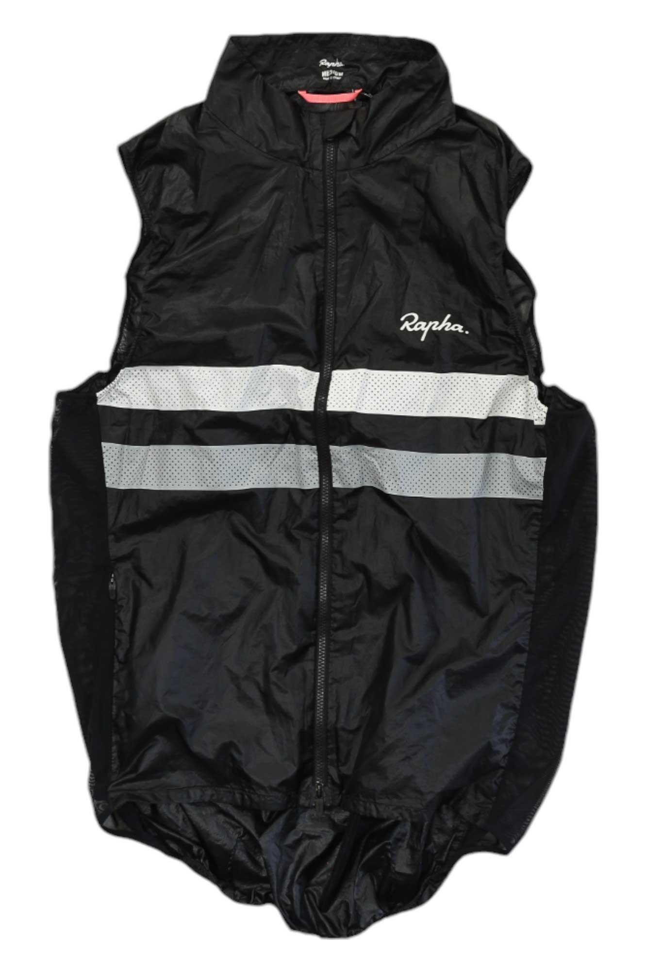 The Rapha Mens Brevet Gilet in black features a full front zipper, high collar, white reflective chest stripes, and Rapha logo on the upper left. This breathable cycling vest is shown flat on a white background.