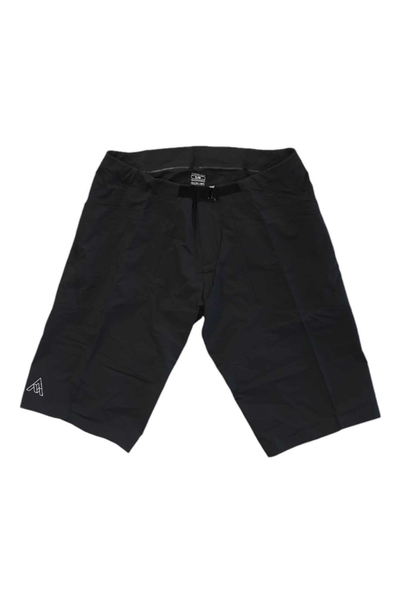 The 7mesh Mens Glidepath Short is a pair of black cycling shorts featuring a drawstring waistband and a small white logo on the lower left leg, displayed flat on a white background.