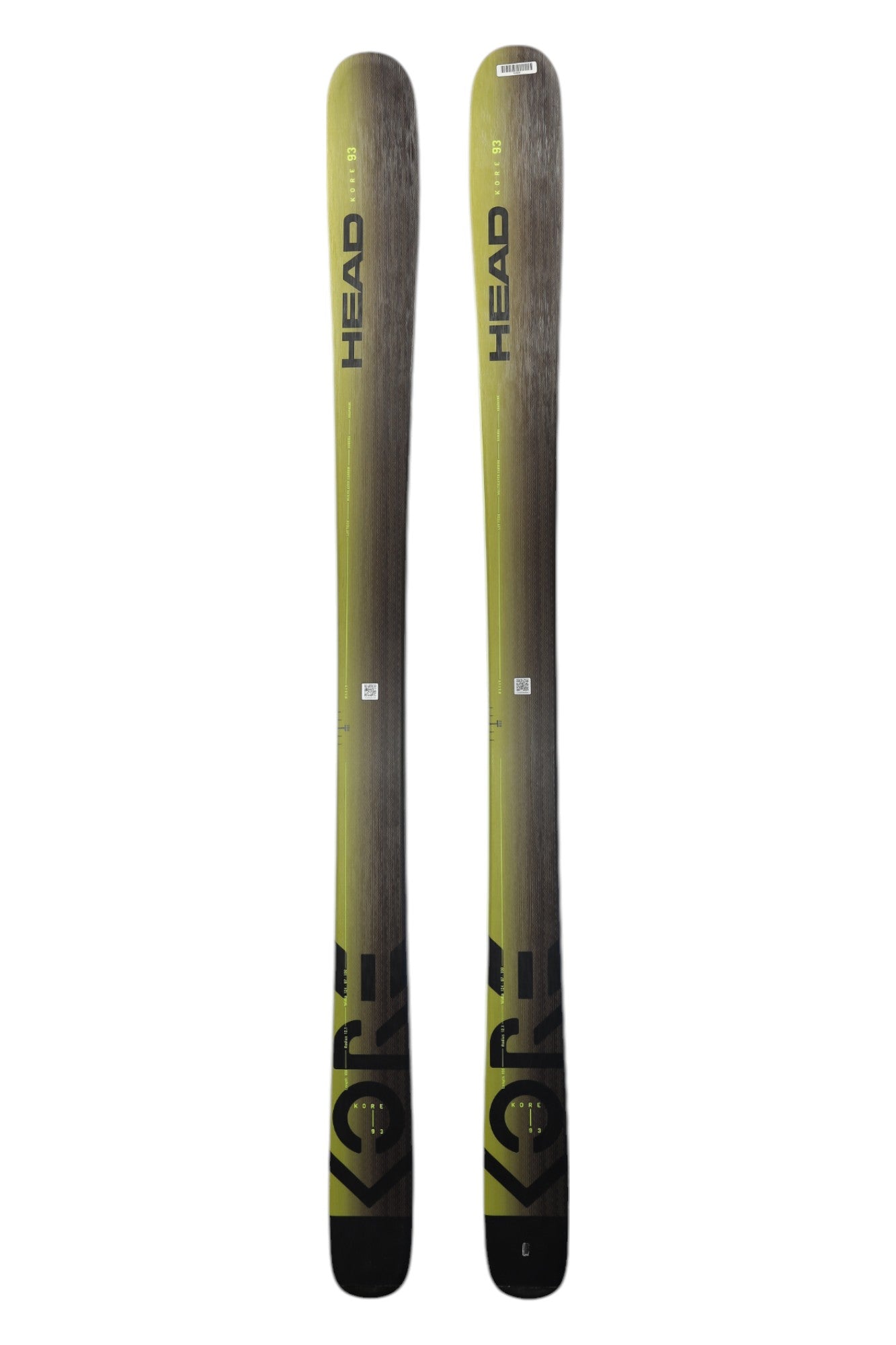 A pair of HEAD Kore 93 alpine skis, mostly gray with yellow accents, stand upright side by side. These lightweight all-mountain skis display the HEAD branding and Kore 93 model clearly.