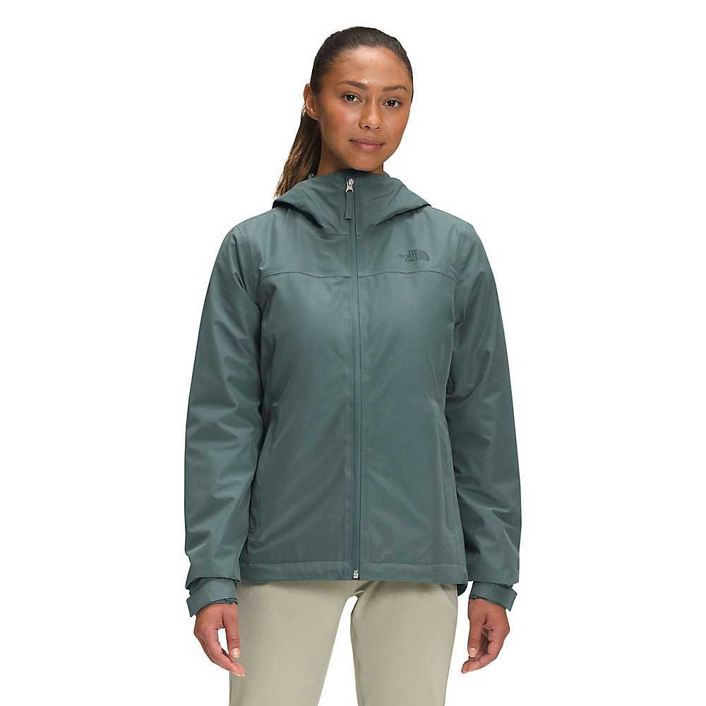 A woman wearing The North Face Womens Dryzzle FUTURELIGHT Insulated Jacket in green and beige pants stands facing forward against a plain white background.