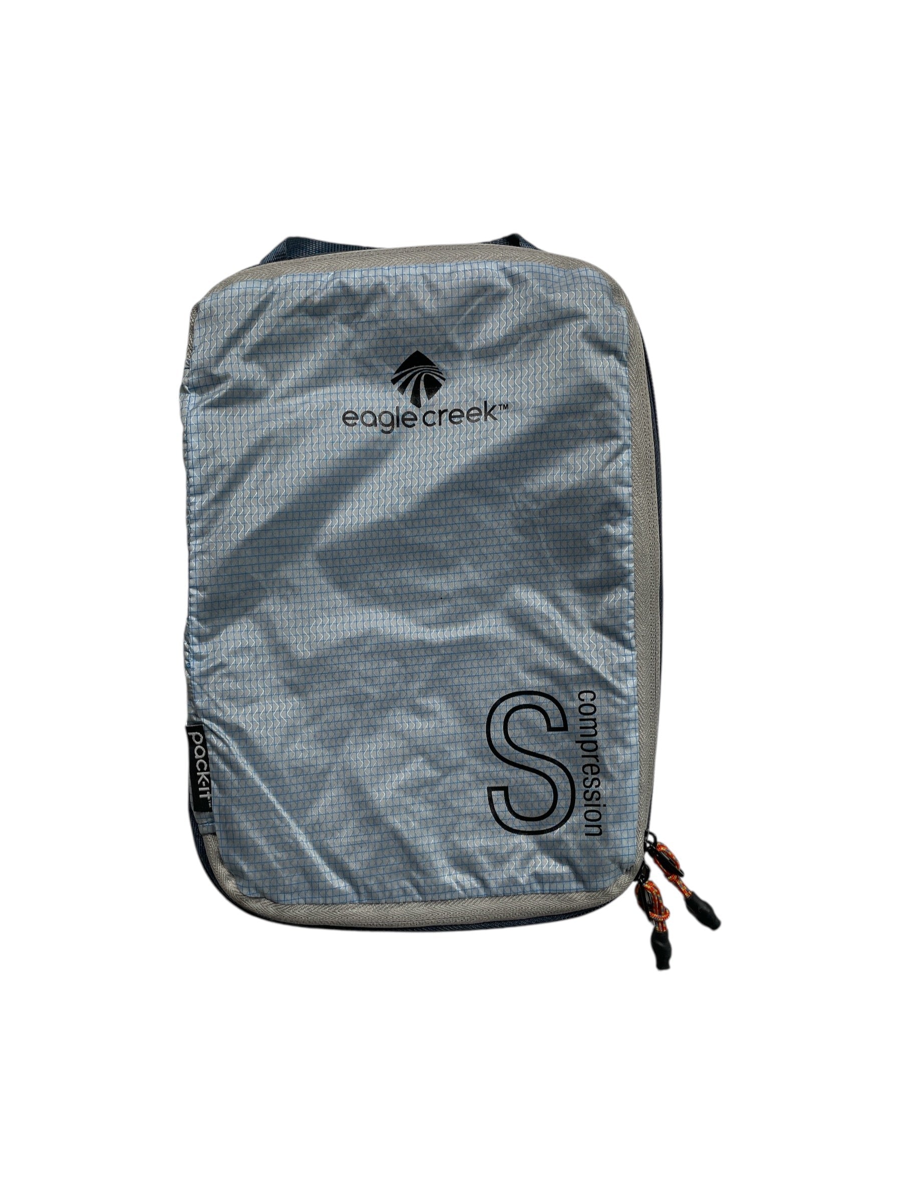 A gray Eagle Creek Pack-It Isolate Compression Cube in size S, made from ocean-recycled fabric with a zippered closure and black logo, is shown on a white background.