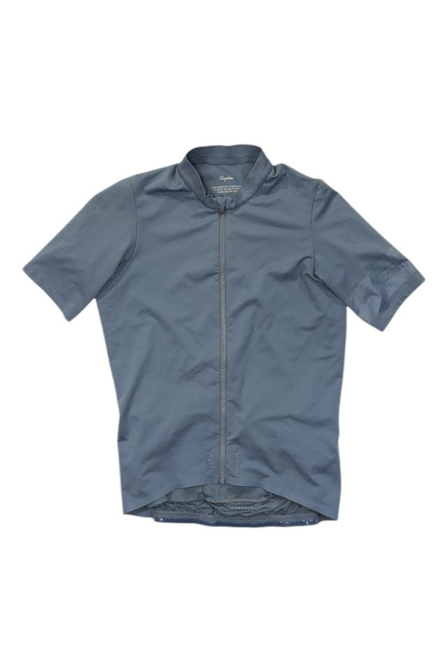 The Mens Pro Team Midweight Short Sleeve Jersey in light blue is a men’s cycling jersey with a front zipper and longer back hem, laid flat on a white background.