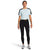 A woman faces forward, wearing a light blue short-sleeve athletic top with black accents, The North Face Womens Active Trail High-Rise Waist Pack Tight pants, and gray athletic shoes against a plain white background.