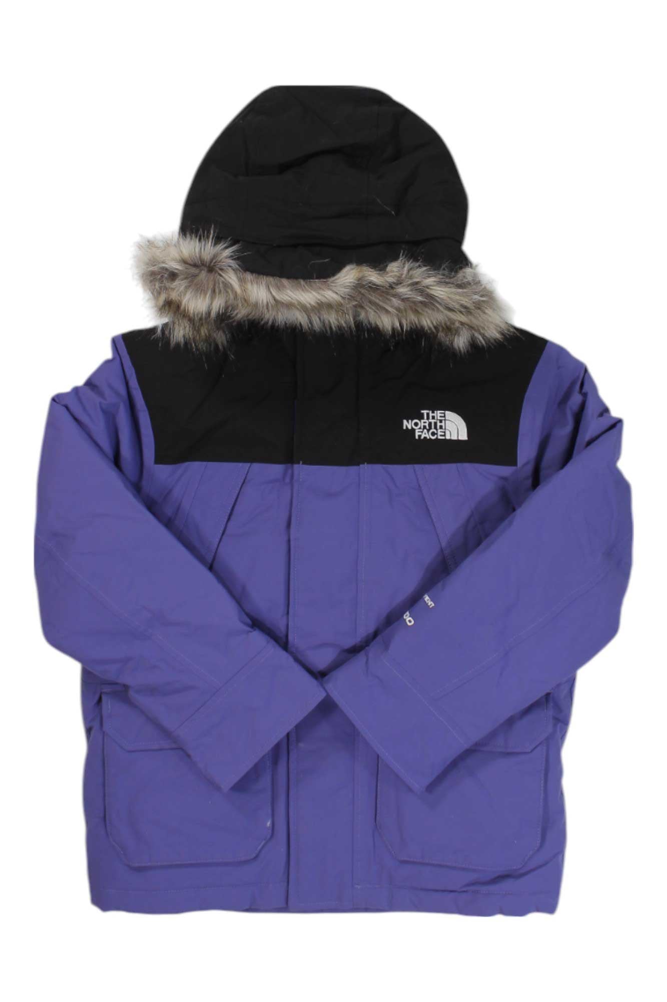 A purple and black The North Face Boys McMurdo Parka winter jacket with a faux fur-trimmed hood, long sleeves, and two large front pockets is laid flat on a white background.