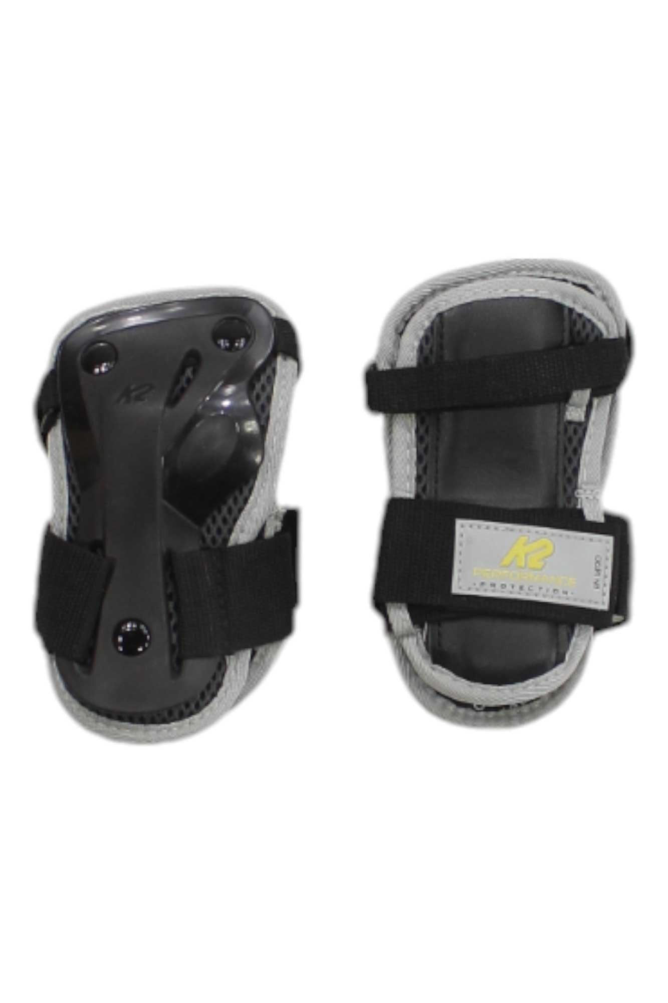 Two K2 Performance Mens Wrist Guards in black and gray with adjustable straps are displayed side by side on a white background, designed to provide protection during inline skating or skateboarding.