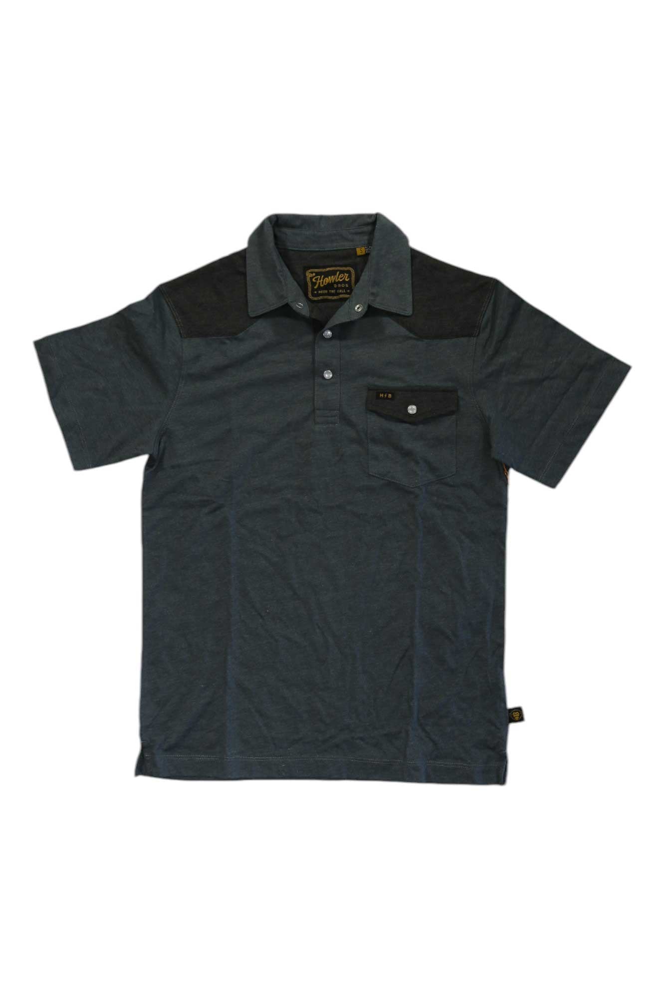 The Howler Brothers Mens Ranchero Polo is a dark gray, short-sleeve shirt with black shoulder panels, a button placket, and a black chest pocket featuring a button and label. Its vintage-inspired style offers a casual look.