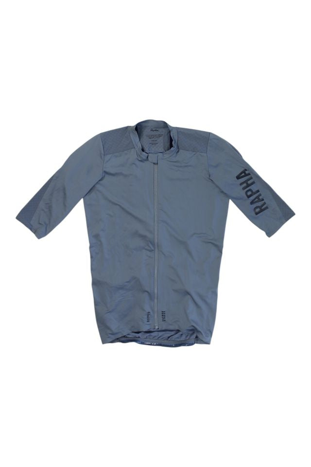 The Pro Team Aero Jersey II is a gray short-sleeved cycling jersey featuring a front zipper and RAPHA printed in large letters on the left sleeve.