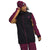 A person wearing the maroon The North Face Mens Freedom Stretch Jacket with tan accents, paired with matching maroon pants and a beanie, smiles while adjusting their hat against a plain white background.