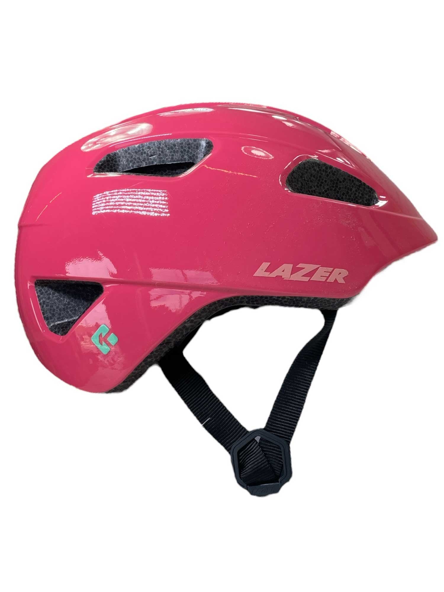 The Lazer Kids Nutz Kineticore Helmet is a shiny pink kids helmet with ventilation holes, a black adjustable chin strap, and the Lazer logo on the side—ideal for child safety while riding.