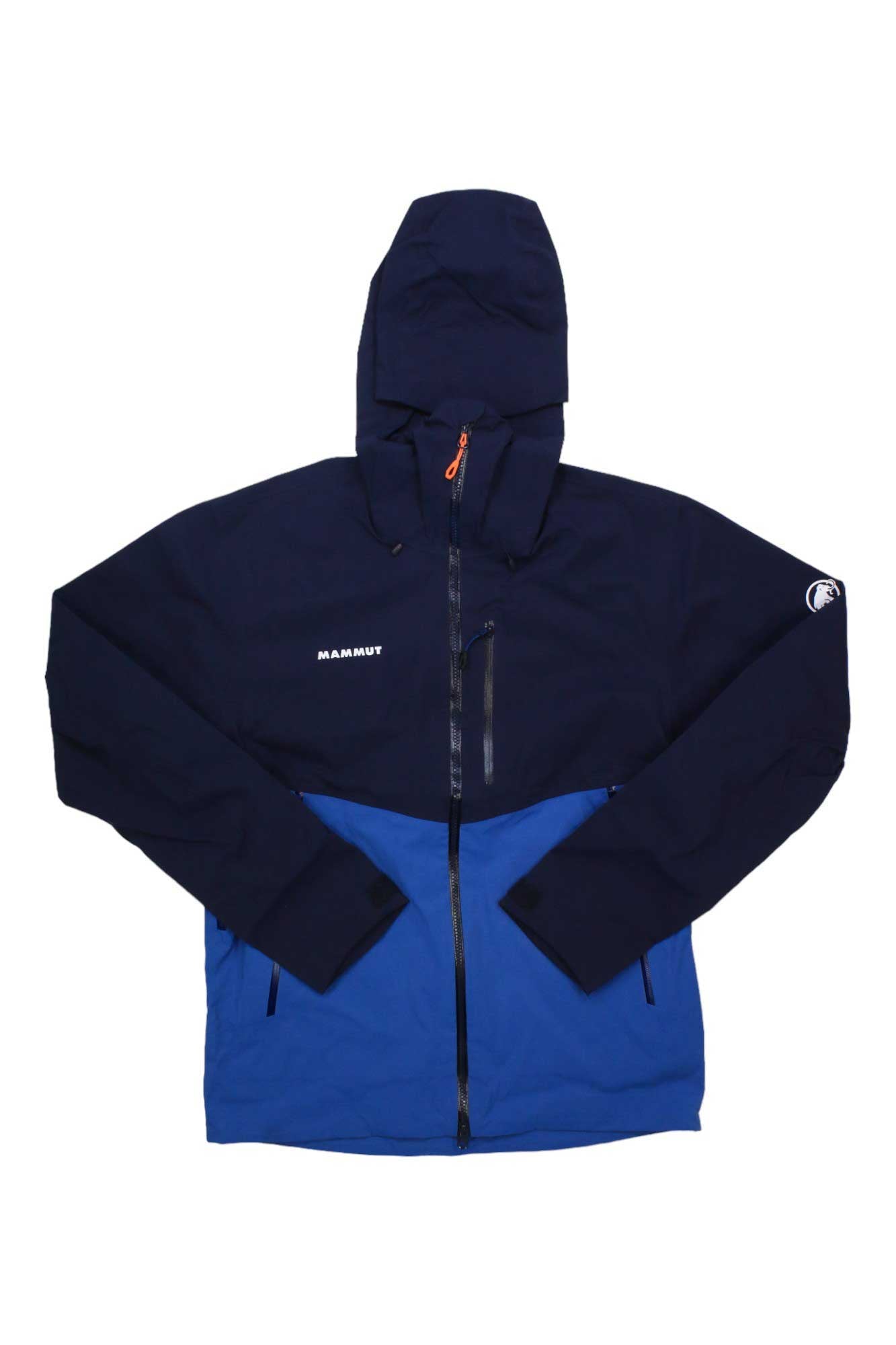 The Mammut Mens Alto Guide HS Hooded Jacket features a navy top and sleeves, bright blue lower, helmet-compatible hood, front zipper, zip chest pocket, and Mammut logos—ideal as a waterproof climbing jacket.