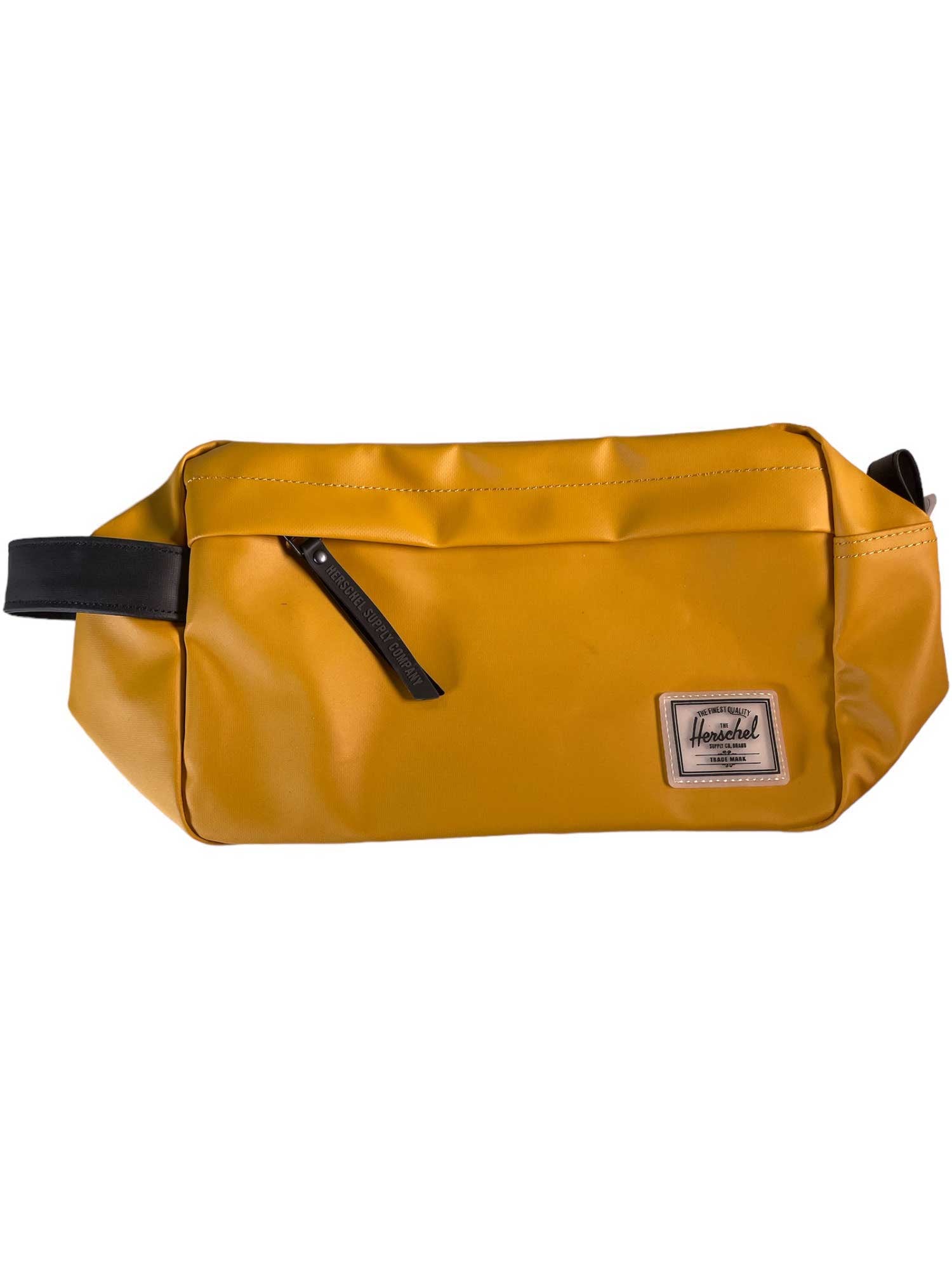 The Herschel Supply Company Chapter Travel Kit is rectangular, mustard yellow, made from recycled fabric, and features a black zipper, handle, and a sewn logo patch on the front.