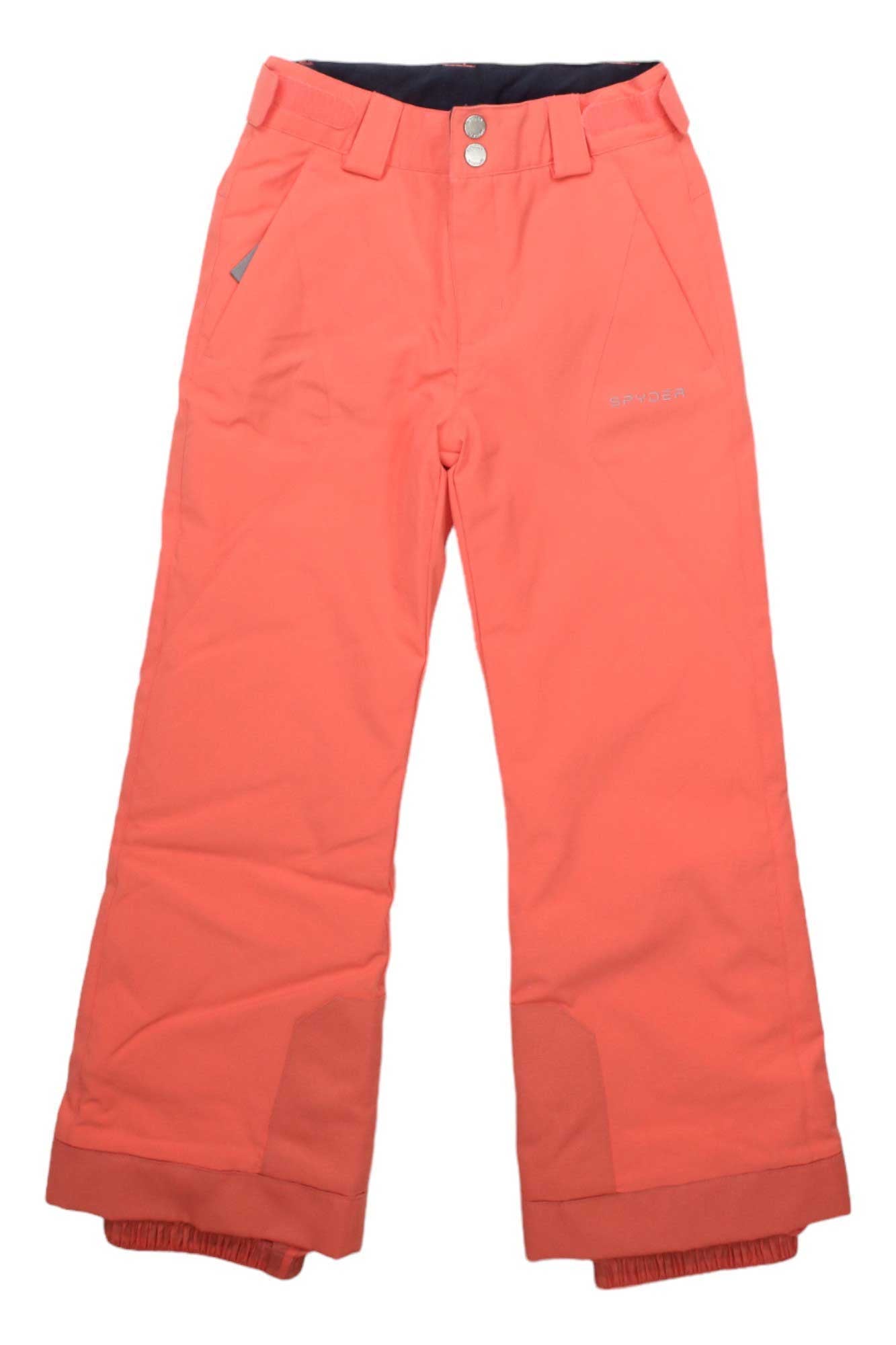 The Spyder Girls Olympia Pant comes in bright coral orange with front pockets, belt loops, reinforced cuffs, an adjustable waist, front button and zipper closure, brand logo on the right side, and waterproof insulation for cold weather.