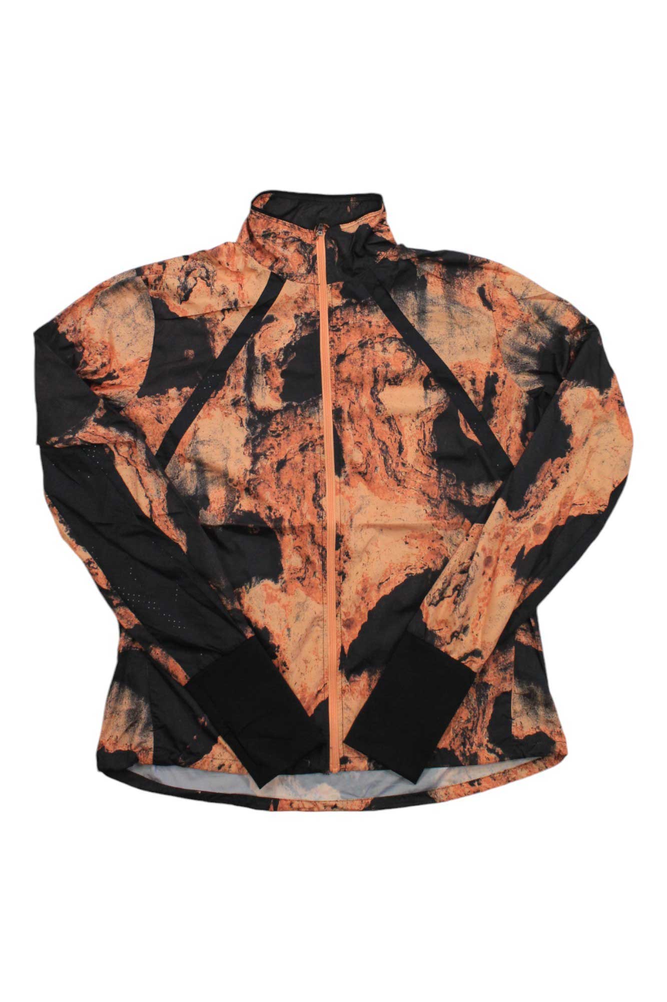 The Craft Sportswear Women's Adv Essence Wind Jacket is a long-sleeve windbreaker with an abstract orange and black marbled design, made from recycled polyester, featuring a high collar and front zipper.