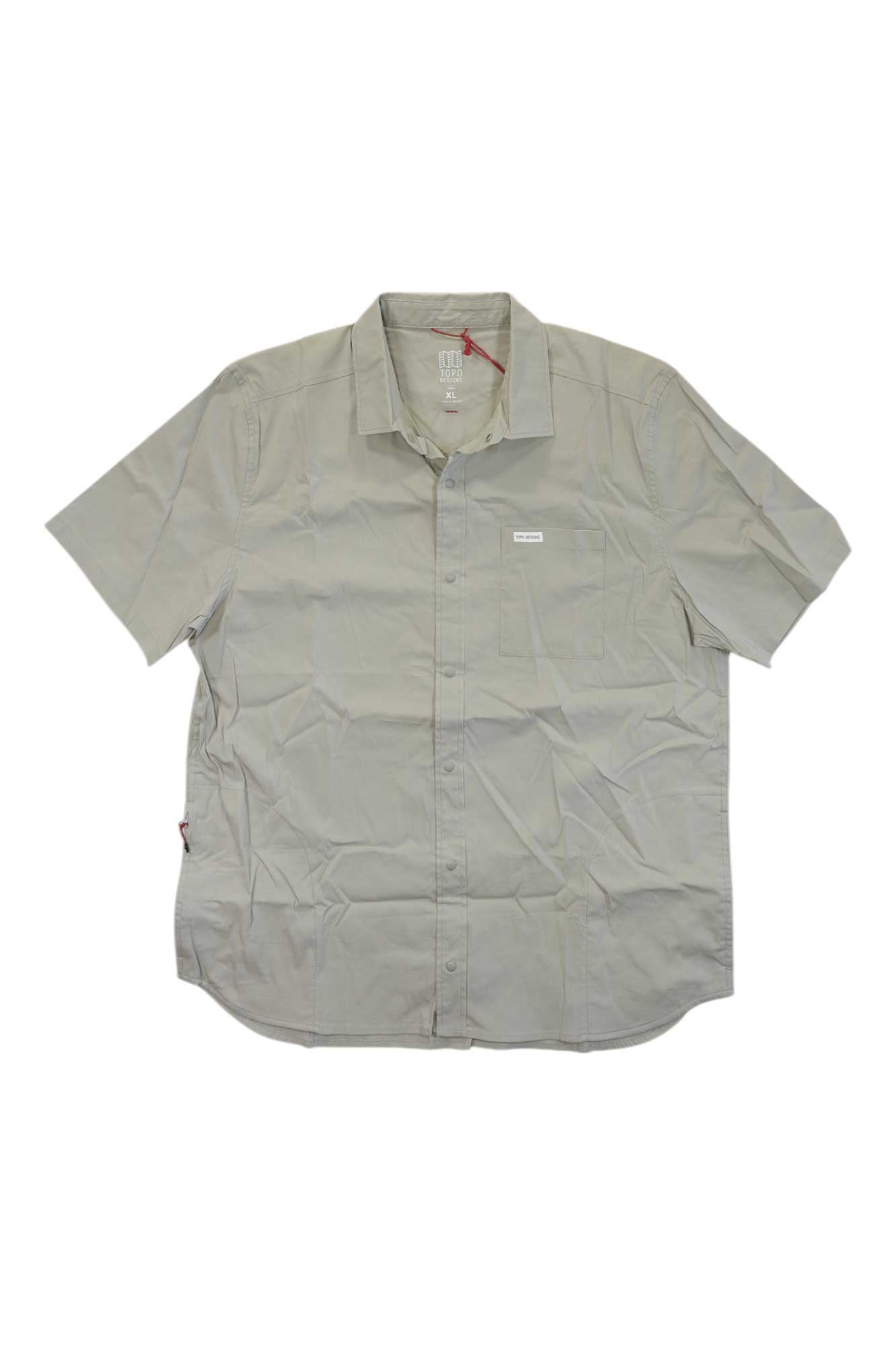 The Topo Designs Mens Global SS Shirt, in light gray with short sleeves, a collar, and a small chest logo, features a slightly wrinkled look—ideal as a versatile travel shirt.
