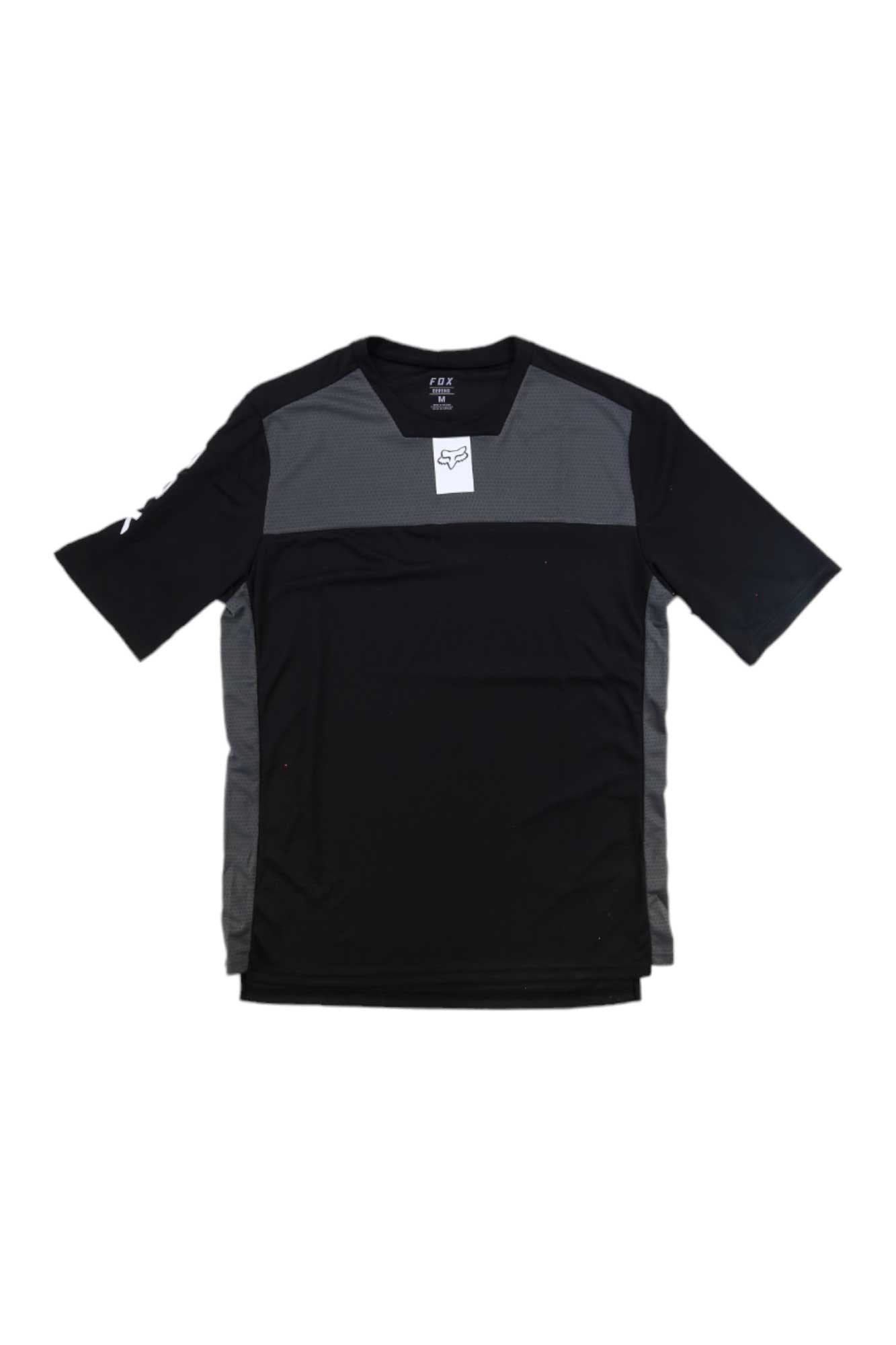The Fox Mens Defend SS Jersey is a black and dark gray short-sleeve athletic shirt with a crew neckline, TruDri fabric, and a small white neck tag, shown flat on a white background.