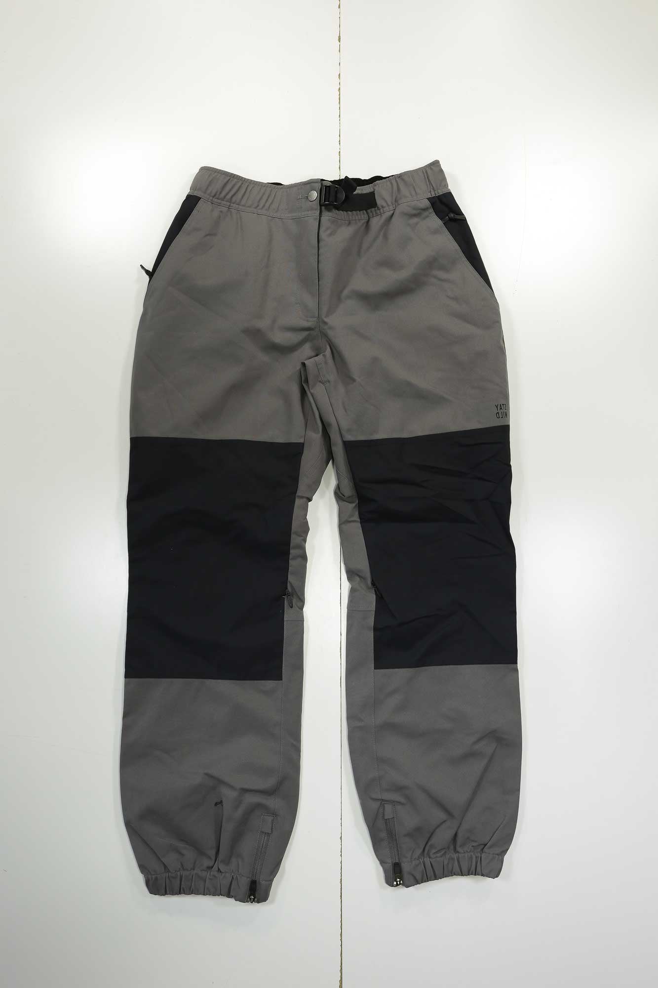 The Airblaster Mens Elastic Boss Pant in gray and black features an elastic waistband, buckle closure, zippered pockets, and elastic cuffs; shown laid flat on a white surface.