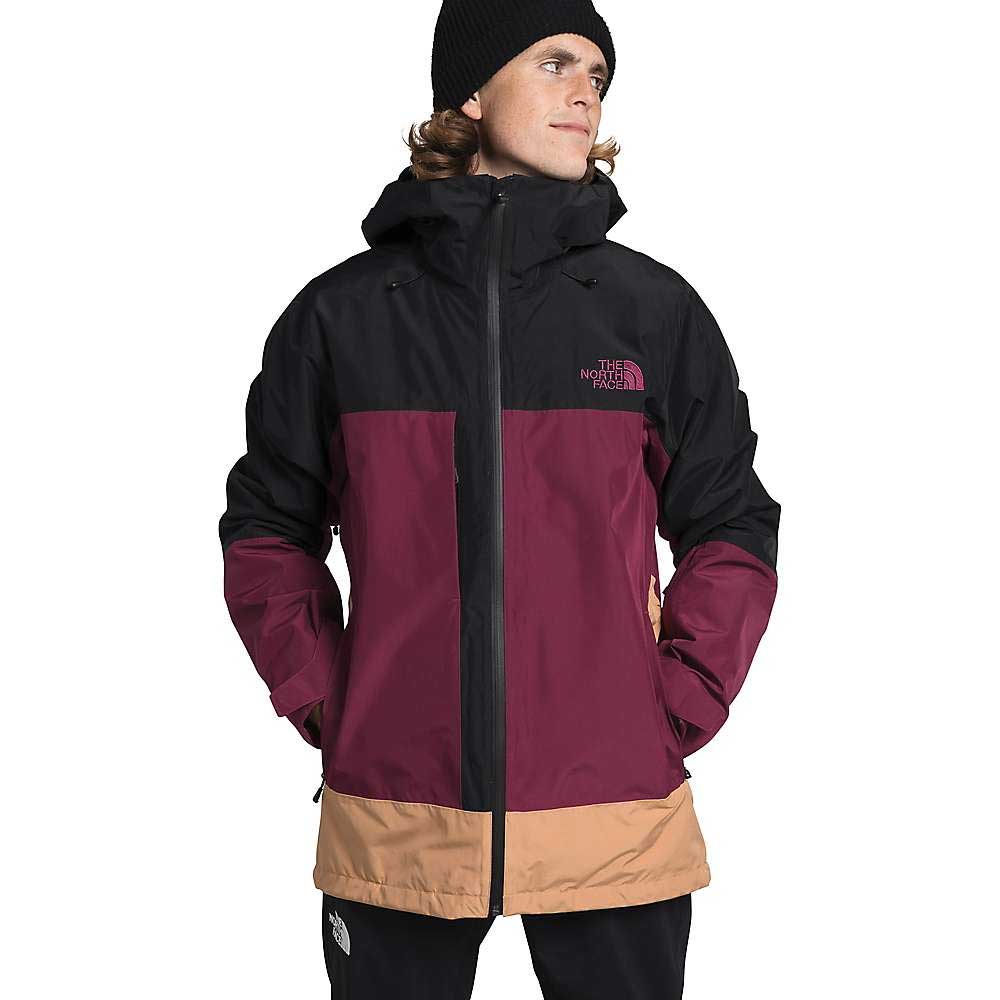 A young man in a black beanie and The North Face Mens Thermoball Eco Snow Triclimate Jacket in black, maroon, and tan stands against a white background.